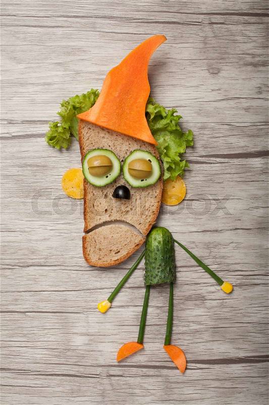 Halloween zombie in hat made of bread vegetables on board, stock photo