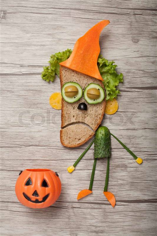 Halloween zombie made of bread vegetables on wooden background, stock photo