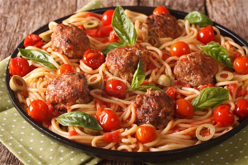 Italian food: spaghetti with meatballs, olives, basil and tomato sauce closeup on a plate. horizontal , stock photo