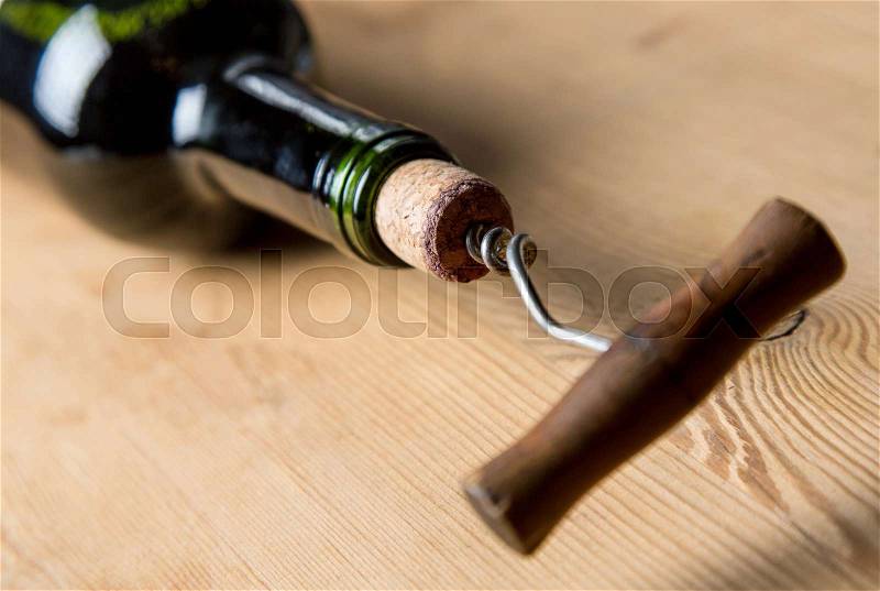 Old corkscrew opening a bottle of wine, stock photo