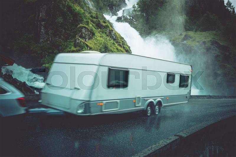 Travel Trailer Vacation Trip. Caravaning on the Road. Speeding Car with Travel Trailer on the Norway Scenic Road, stock photo