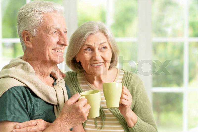 Portrait of a happy senior couple drinking tea, stock photo