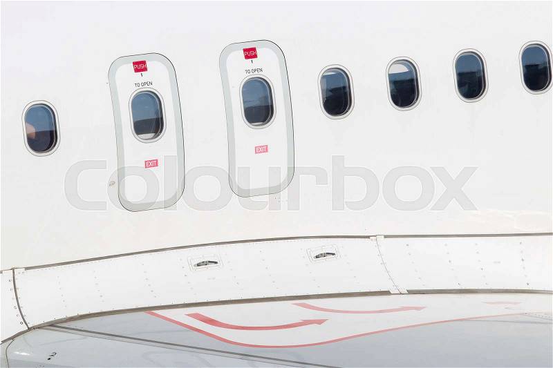 Windows of airplane with emergency exit door, stock photo