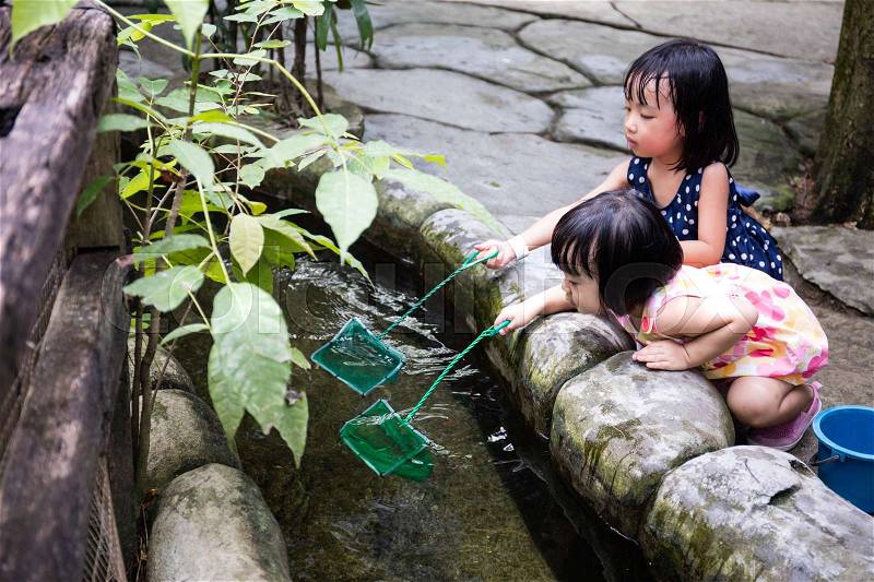 Asian Chinese Little Girls Fishing With Scoop Net At Outdoor Man-made Pond, stock photo