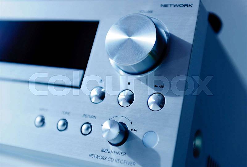 Powerful amplifier CD player panel with brushed metal finish and opened CD tray. Tilt-shift lens used to outline the tray and the CD inside, stock photo