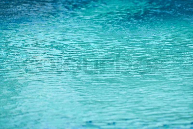 Blue swimming pool rippled water detail. Summer day, stock photo