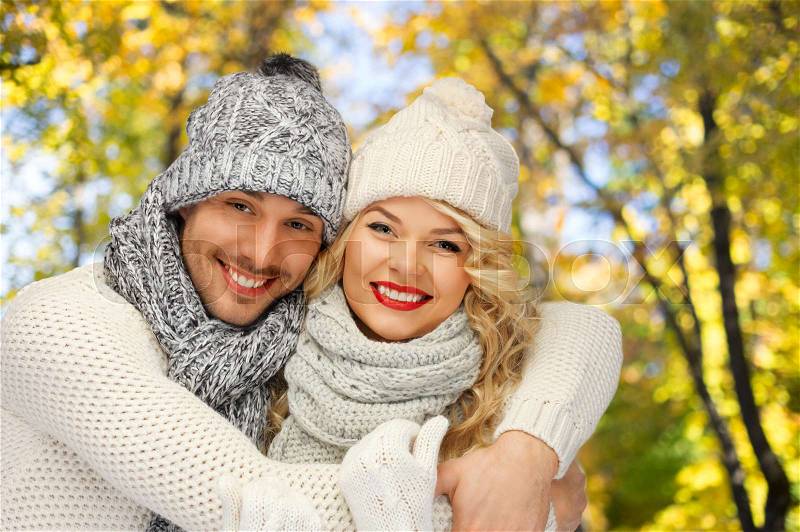 Season, people, love and fashion concept - happy family couple in warm clothes over autumn background, stock photo