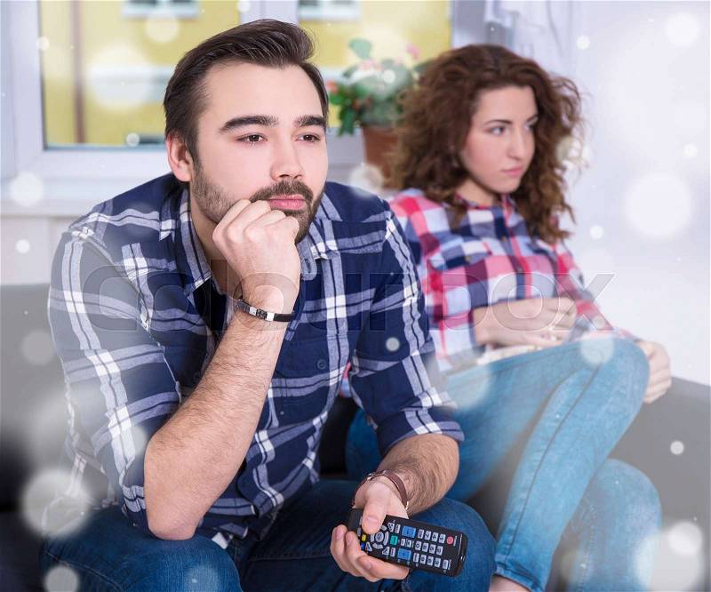 Winter concept - woman being bored watching tv with her boyfriend, stock photo