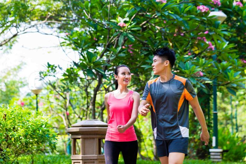 Asian Chinese man and woman jogging in city park, stock photo