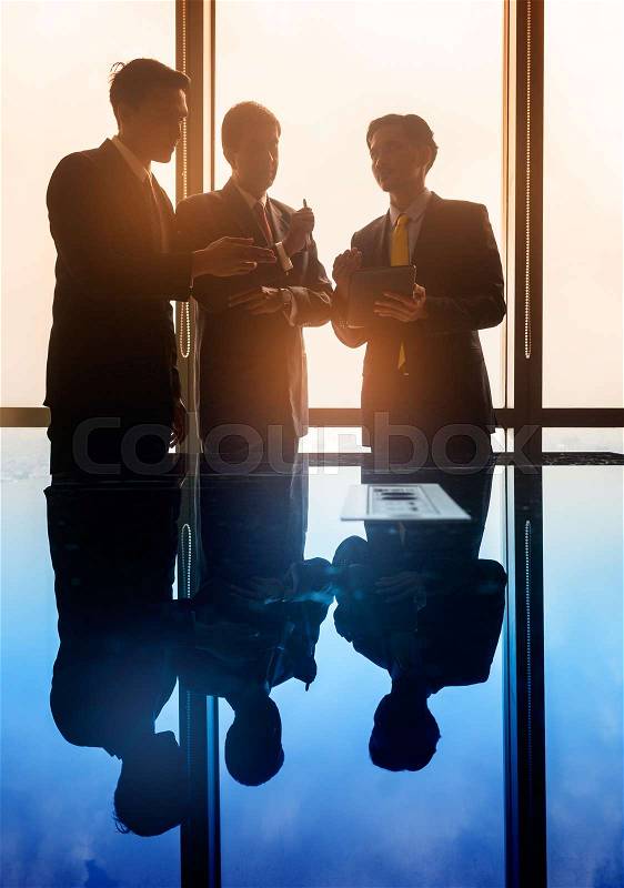 Asian business people having conversation in front of window in conference room, filtered image, stock photo