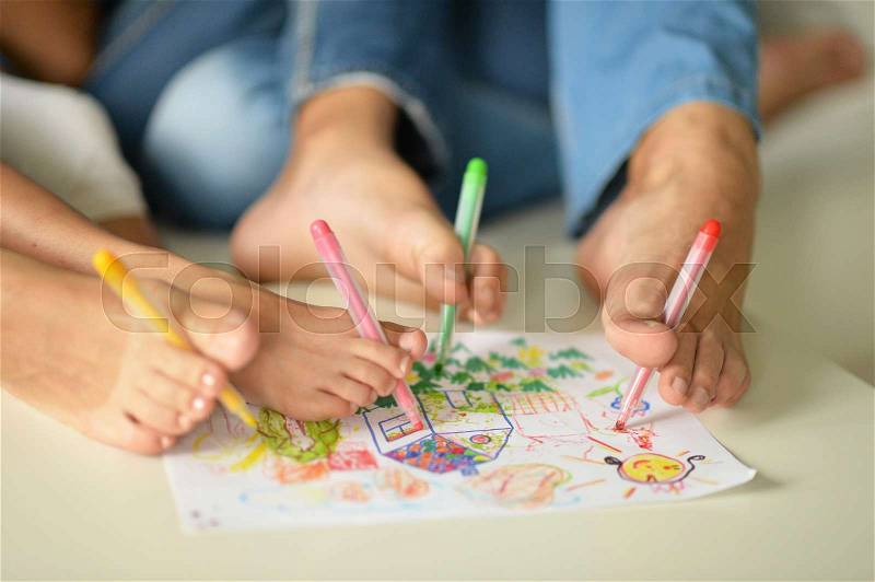 Portrait of happy family painting by their feet at home, stock photo