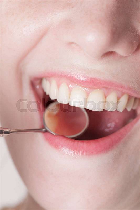 Open mouth of woman with dentist mirror during checking teeth, stock photo