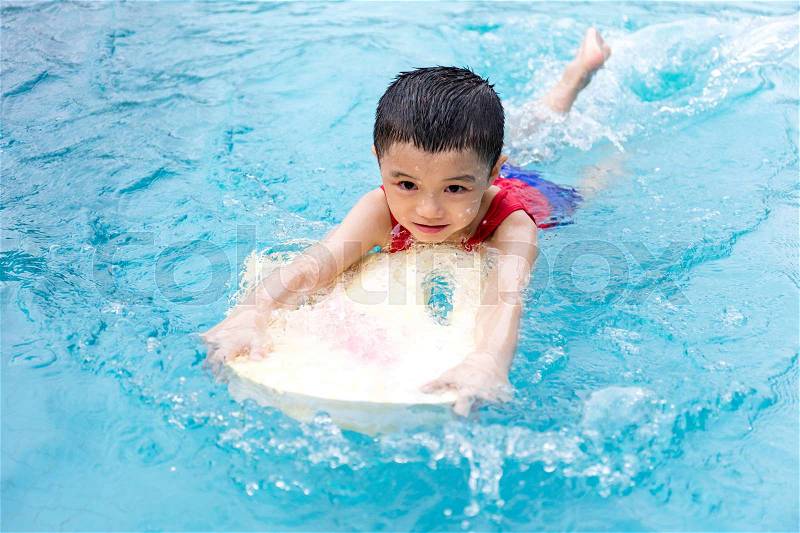 Asian Chinese Little Boy Swimming With Floating Board at Outdoor Swimming Pool, stock photo
