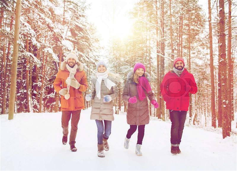 Love, christmas, season, friendship and people concept - group of smiling men and women running in winter forest, stock photo