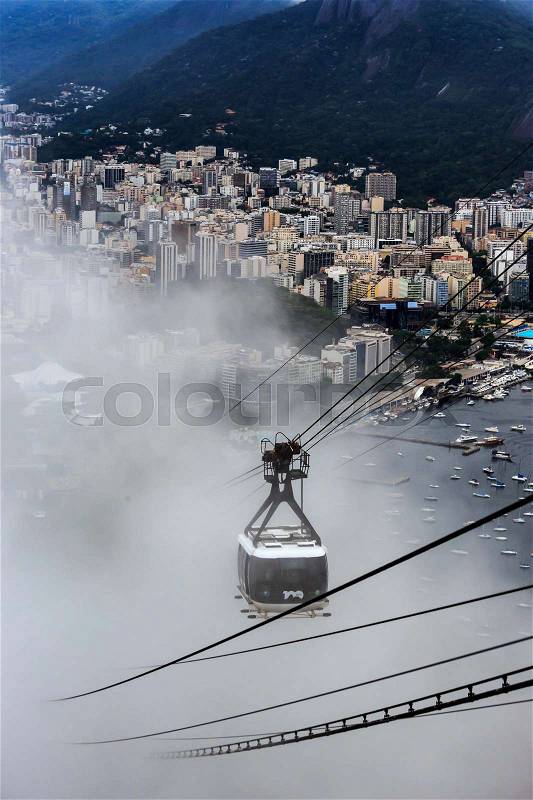 Cable car tin the clouds to the top of SugarLoaf, and city panorama of Rio de Janeiro, stock photo