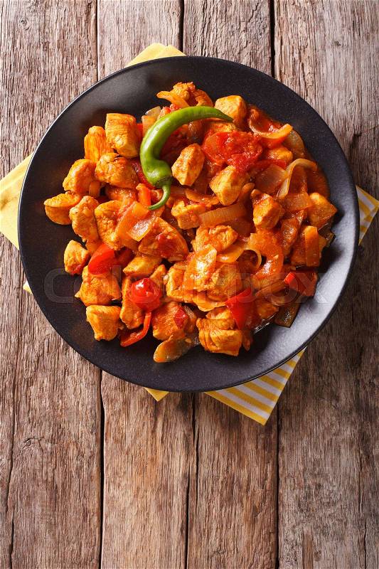 Popular Indian curry Chicken Jalfrezi, chicken stir fried with spices, with a tomato sauce and red and green capsicums. vertical view from above\, stock photo