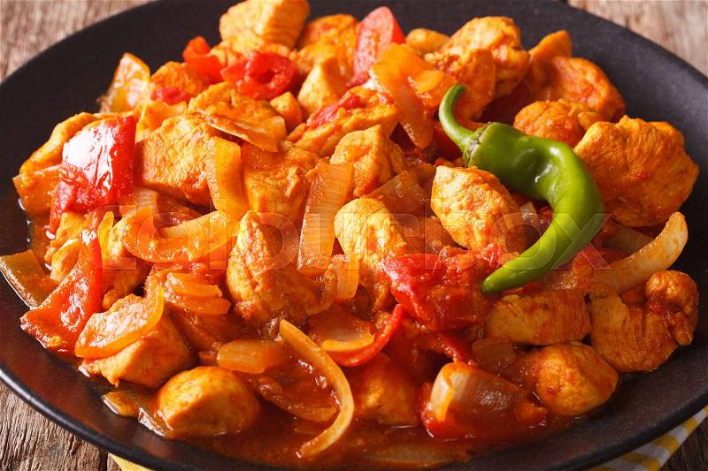 Popular Indian curry Chicken Jalfrezi, chicken stir fried with spices, with a tomato sauce and red and green capsicums macro. horizontal\, stock photo