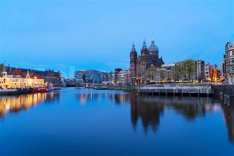 Amsterdam skyline with Church of St Nicholas over old town canal at night, Amsterdam, Holland, stock photo