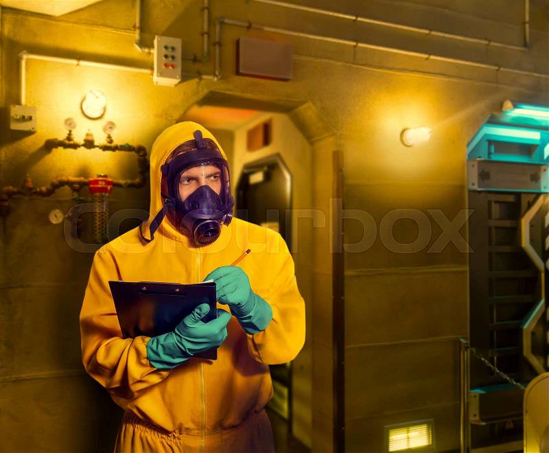 Man in protective suit with respiratory mask making notes, stock photo