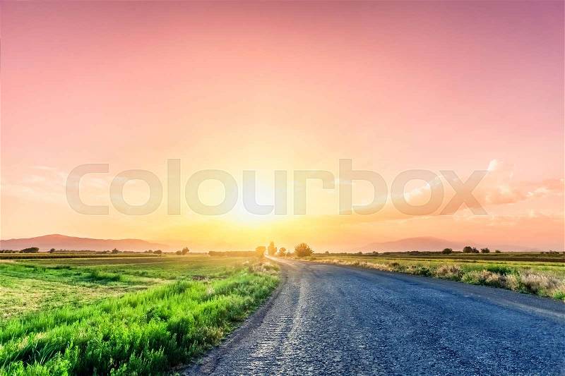 Magnificent landscape of road on meadow on background of beautiful sunset sky with clouds. Exploring Armenia, stock photo