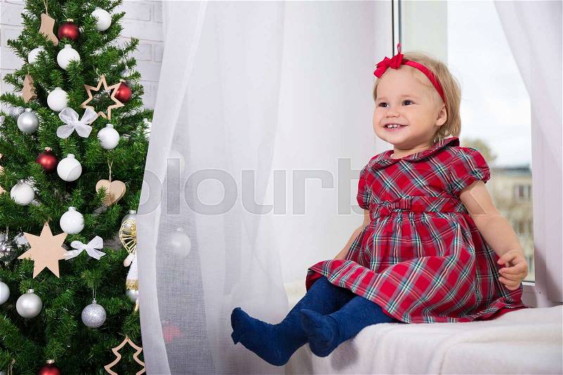 Christmas and family concept - cute little girl and decorated Christmas tree, stock photo