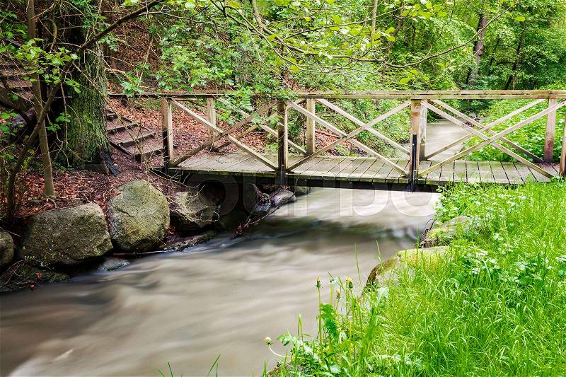 Image of a foot bridge over a small forest creek. Helsingborg, Sweden. , stock photo