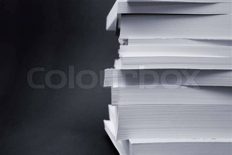 Paperback books (manuals) on a black background, stock photo
