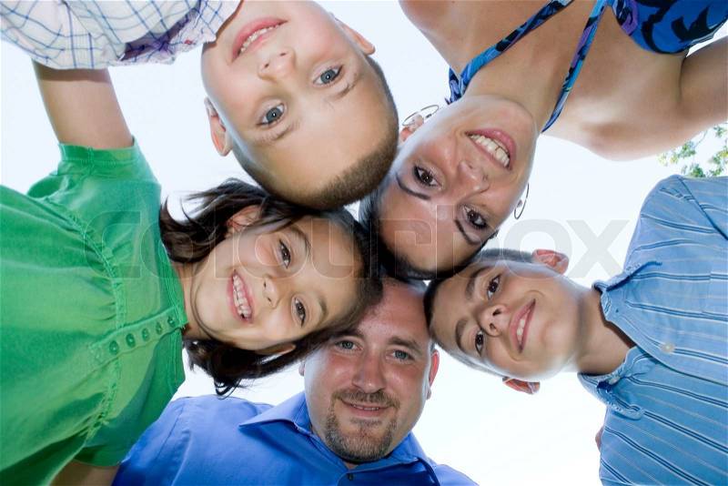 A happy family posing in a group huddle formation, stock photo