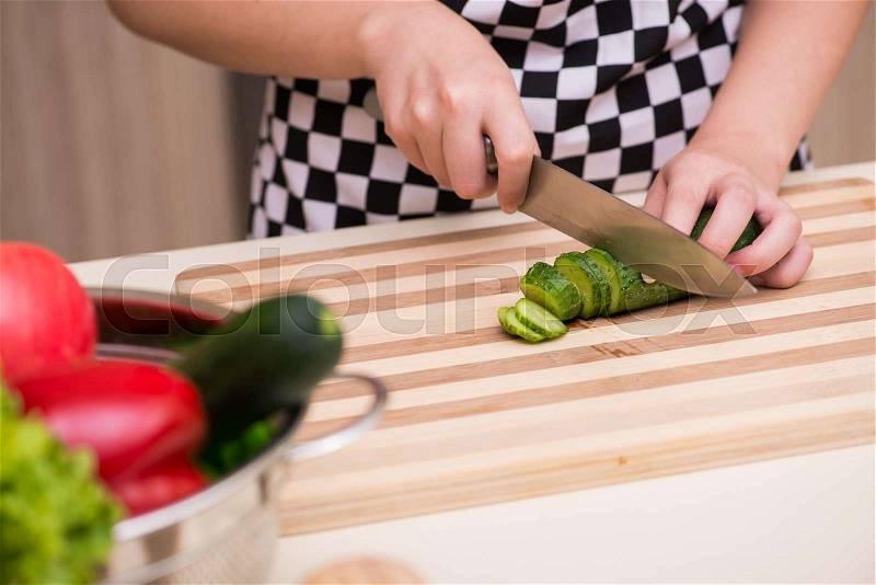 Young woman housewife working in the kitchen, stock photo