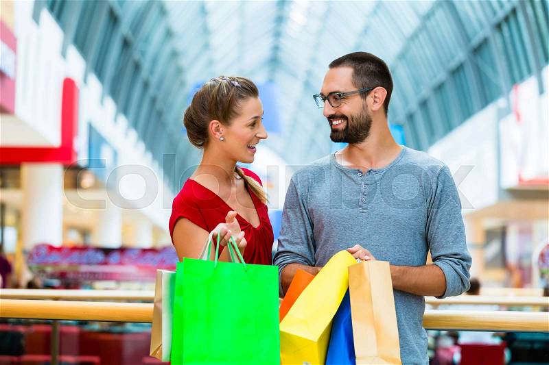 Man and woman in shopping mall with bags, stock photo