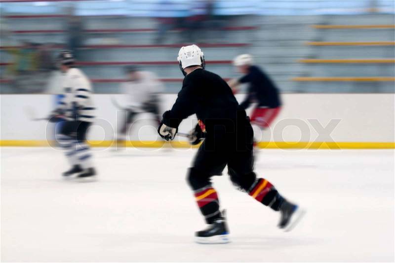 Panned motion blur of two hockey players skating down the ice rink, stock photo