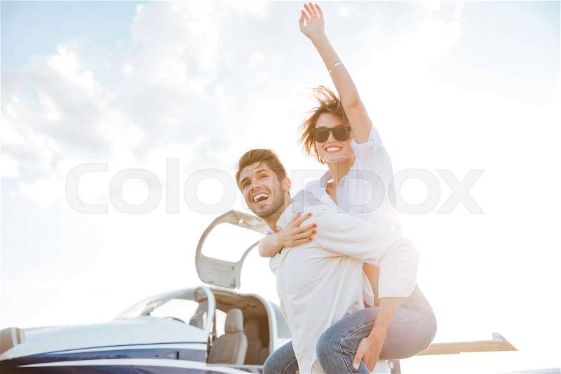 Happy young couple having fun on runway in airport, stock photo