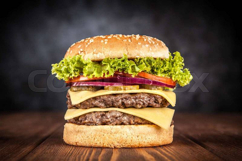 Delicious grilled burger on black background, stock photo