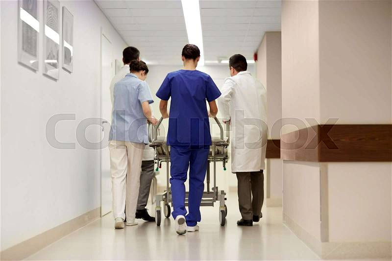 Profession, people, healthcare, reanimation and medicine concept - group of medics or doctors carrying hospital gurney to emergency room, stock photo