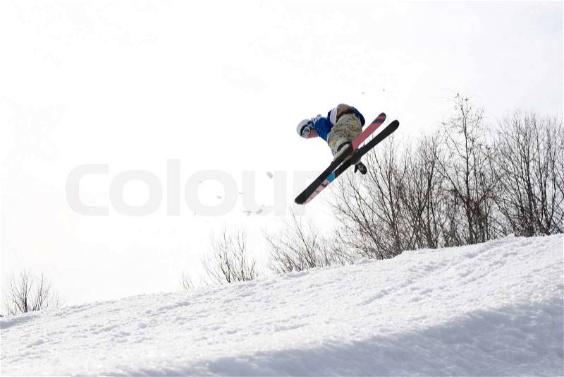 A skier catching some major air after launching off of a jump, stock photo