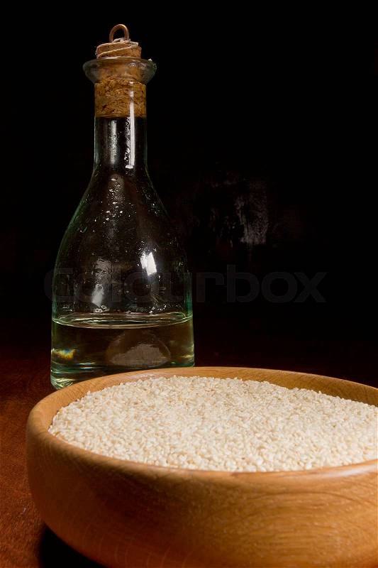 Sesame seeds and sesame oil on a dark background, stock photo
