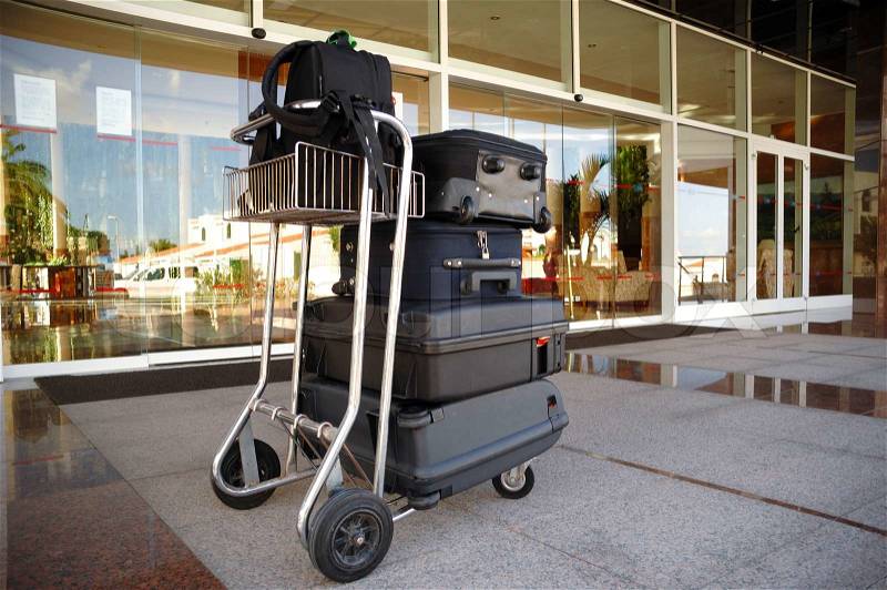 Trolley with suitcases in front of hotel, stock photo