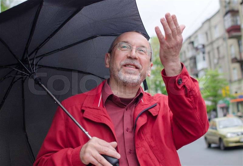 Aged man under the rain with umbrella, stock photo