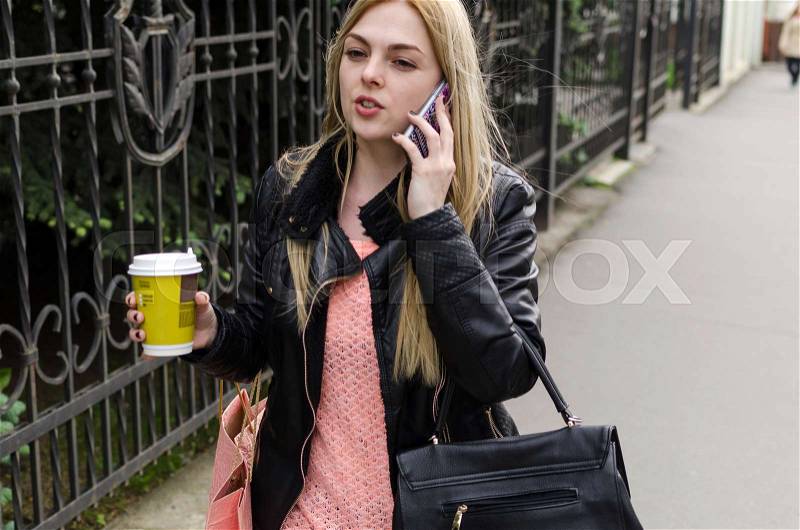 Young woman with a coffee and her cell phone, stock photo