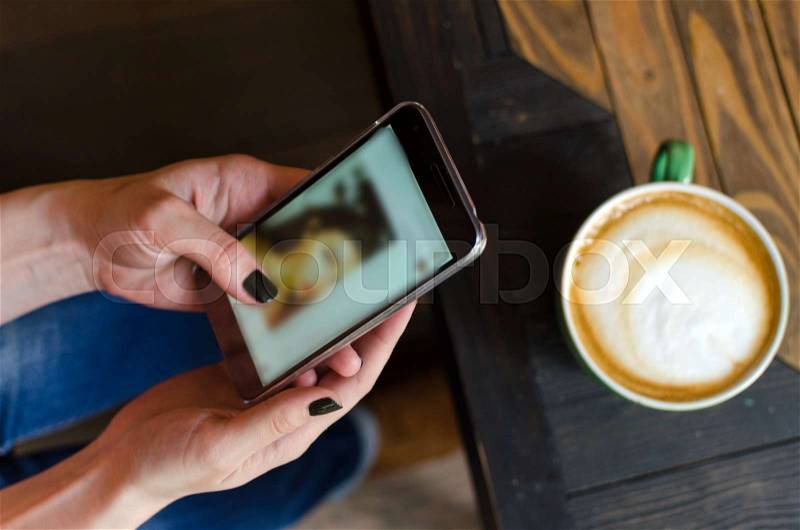 Young woman with a coffee and her cell phone, stock photo