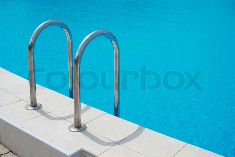 Swimming pool with stair and blue relaxing water, stock photo