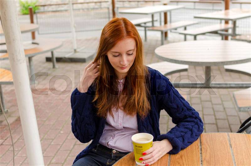Young red woman with hot tasty coffee, stock photo
