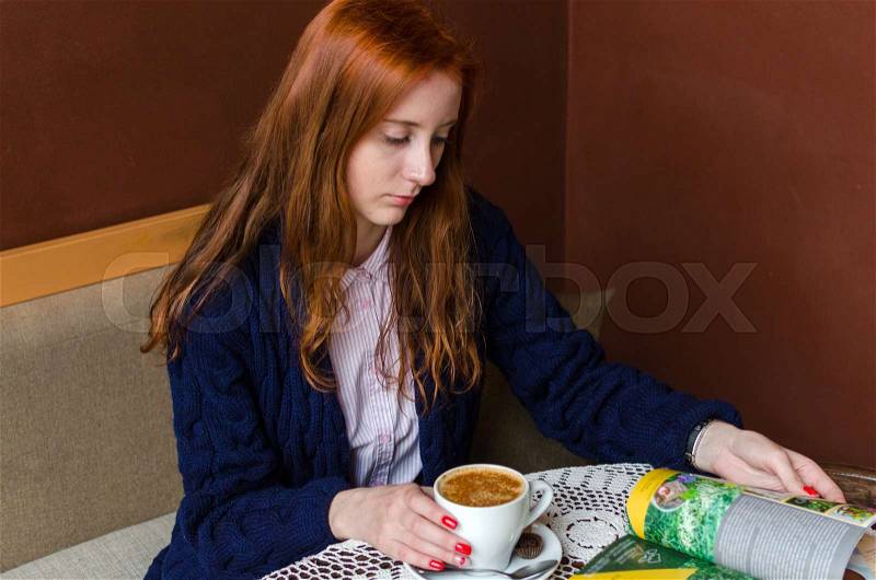 Young red woman with hot tasty coffee, stock photo