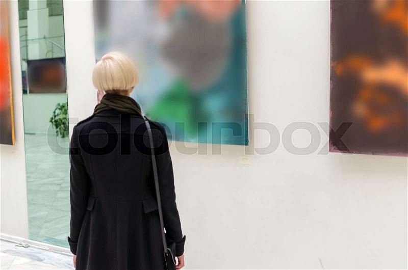 Young girl walking in the empty art gallery, stock photo