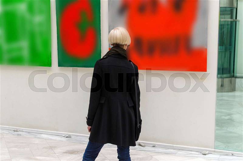 Young girl walking in the empty art gallery, stock photo