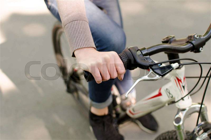 Young beautiful girl riding a white bicycle in the park, stock photo