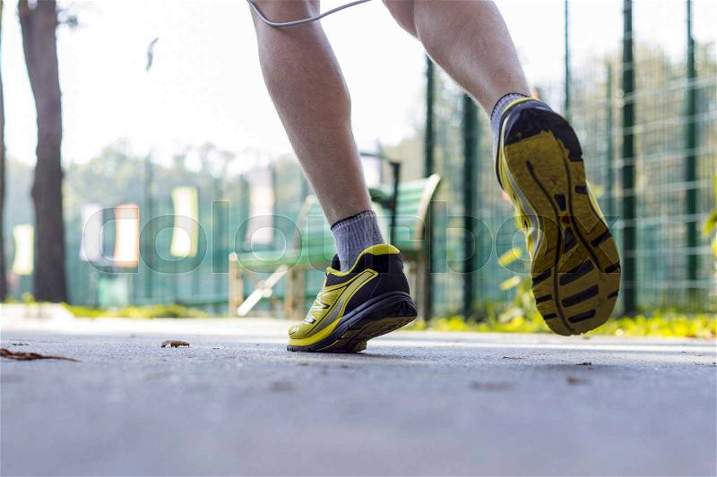 Close up of man's legs in sport shoes in the park, stock photo