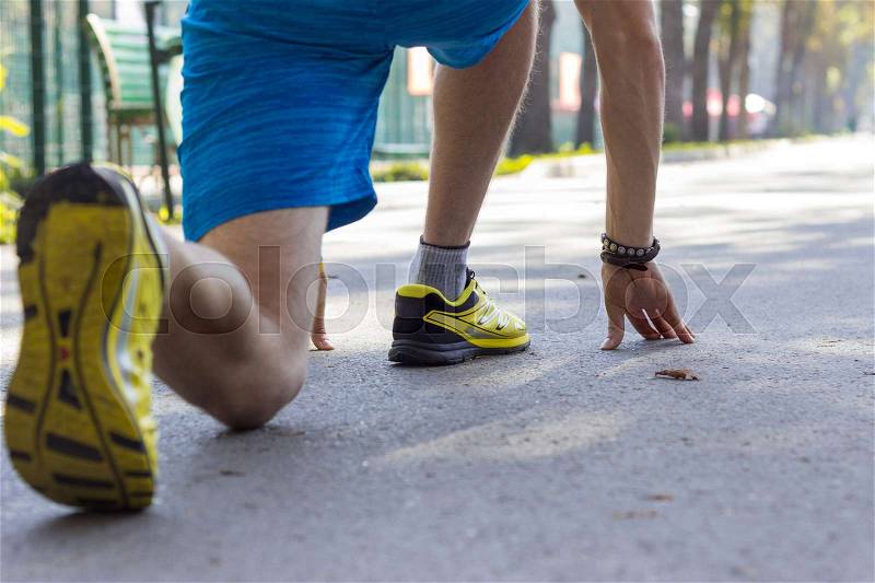 Close up of man\'s legs in sport shoes in the park, stock photo