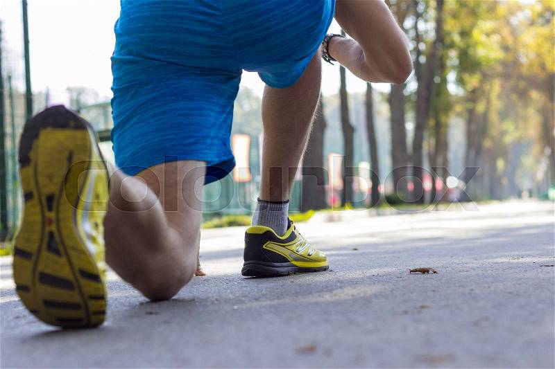 Close up of man\'s legs in sport shoes in the park, stock photo