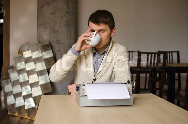 Man is drinking coffee and looking what he typed, stock photo